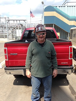 Shane Powell August employee of the month standing in front of Schad truck